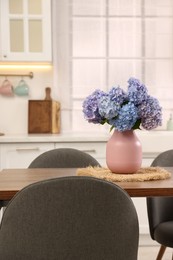 Photo of Dining table, chairs and floral decor in kitchen. Interior design