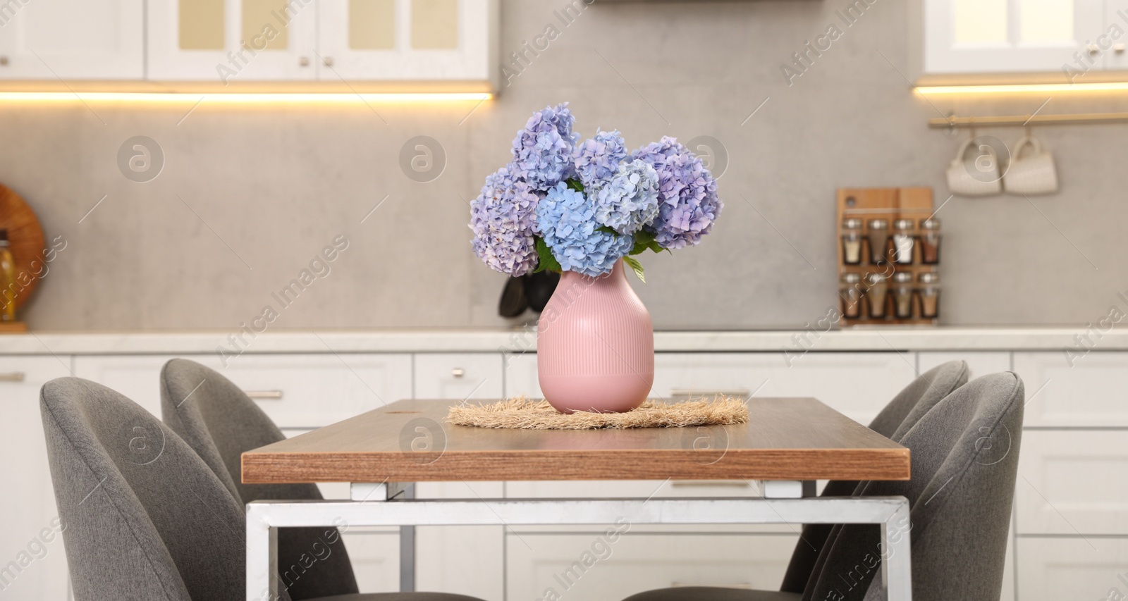 Photo of Dining table, chairs and floral decor in kitchen. Interior design
