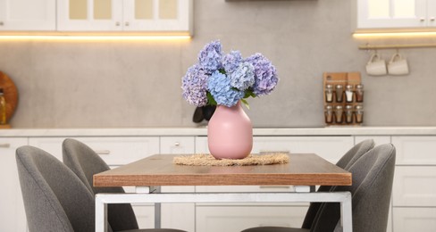 Photo of Dining table, chairs and floral decor in kitchen. Interior design