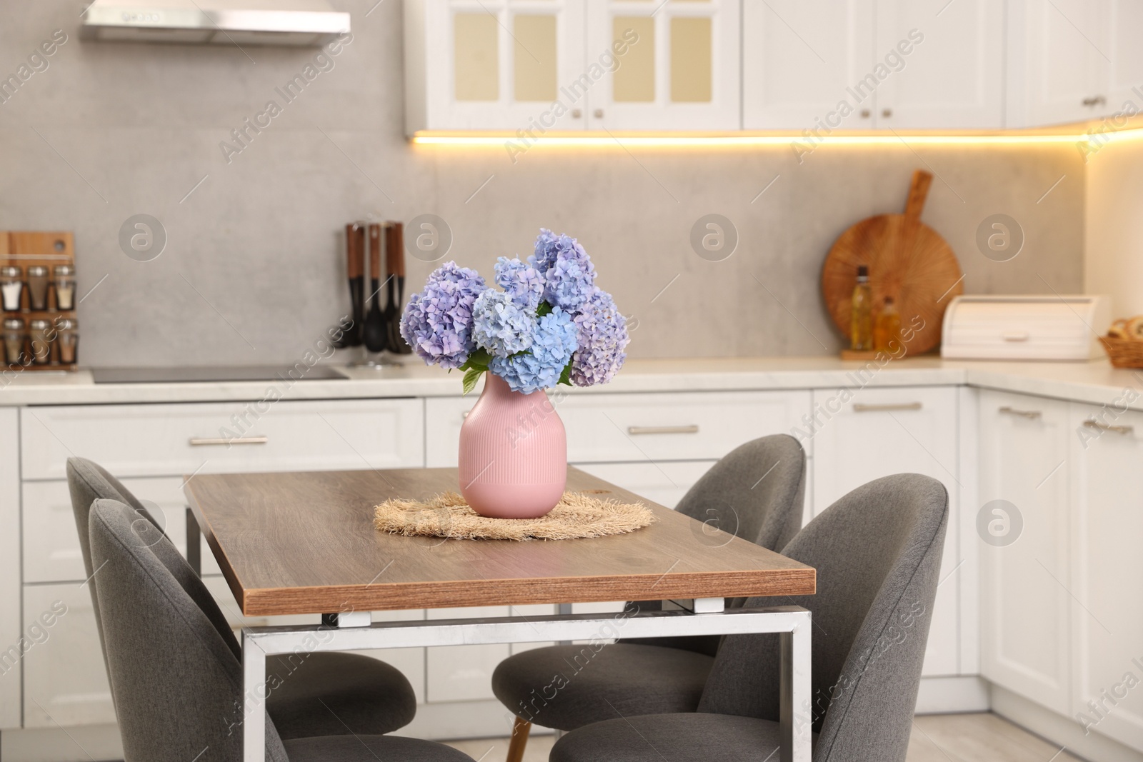 Photo of Dining table, chairs and floral decor in kitchen. Interior design