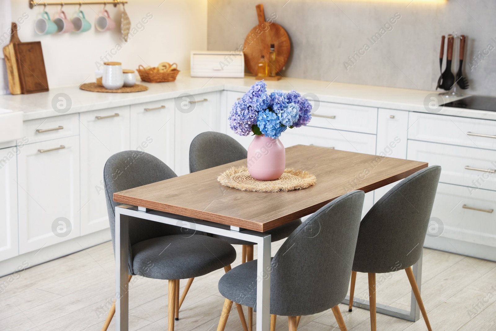 Photo of Dining table, chairs and floral decor in kitchen. Interior design