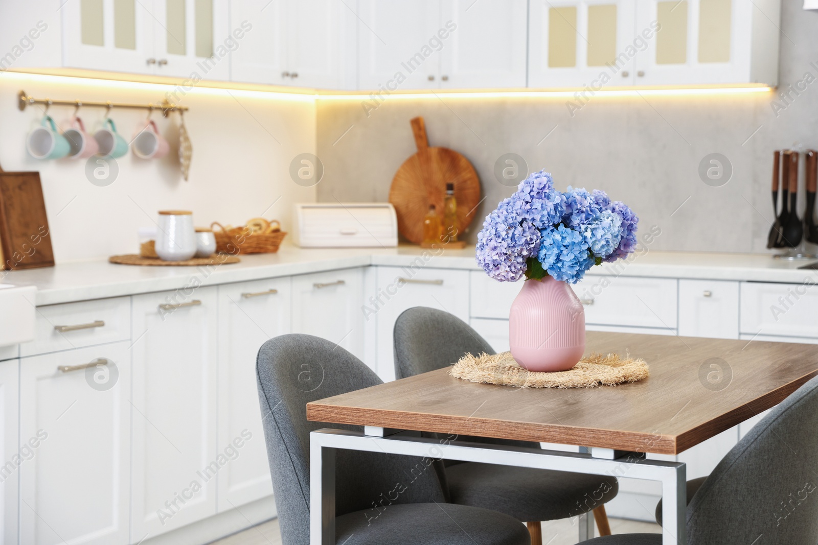 Photo of Dining table, chairs and floral decor in kitchen. Interior design