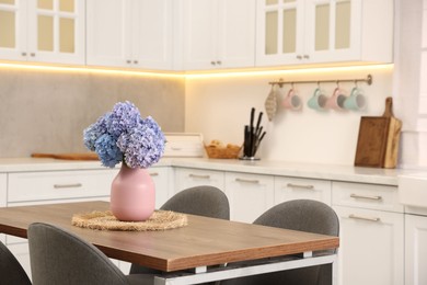 Photo of Dining table, chairs and floral decor in kitchen. Interior design