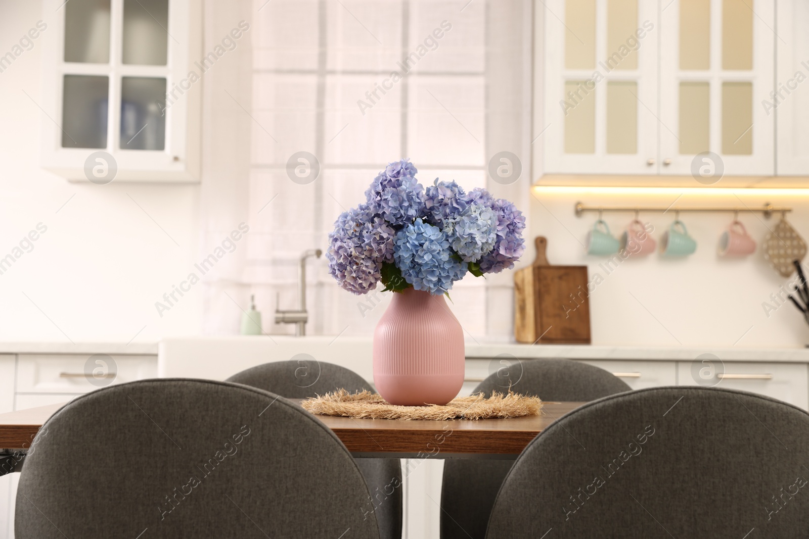 Photo of Dining table, chairs and floral decor in kitchen. Interior design