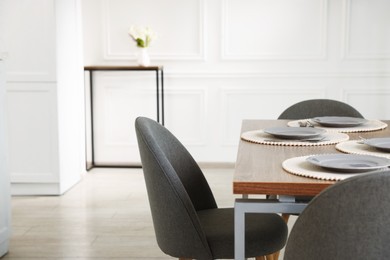 Photo of Stylish table setting and chairs in dining room. Interior design