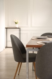 Photo of Stylish table setting and chairs in dining room. Interior design