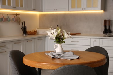 Photo of Dining table, chairs and floral decor in kitchen. Interior design