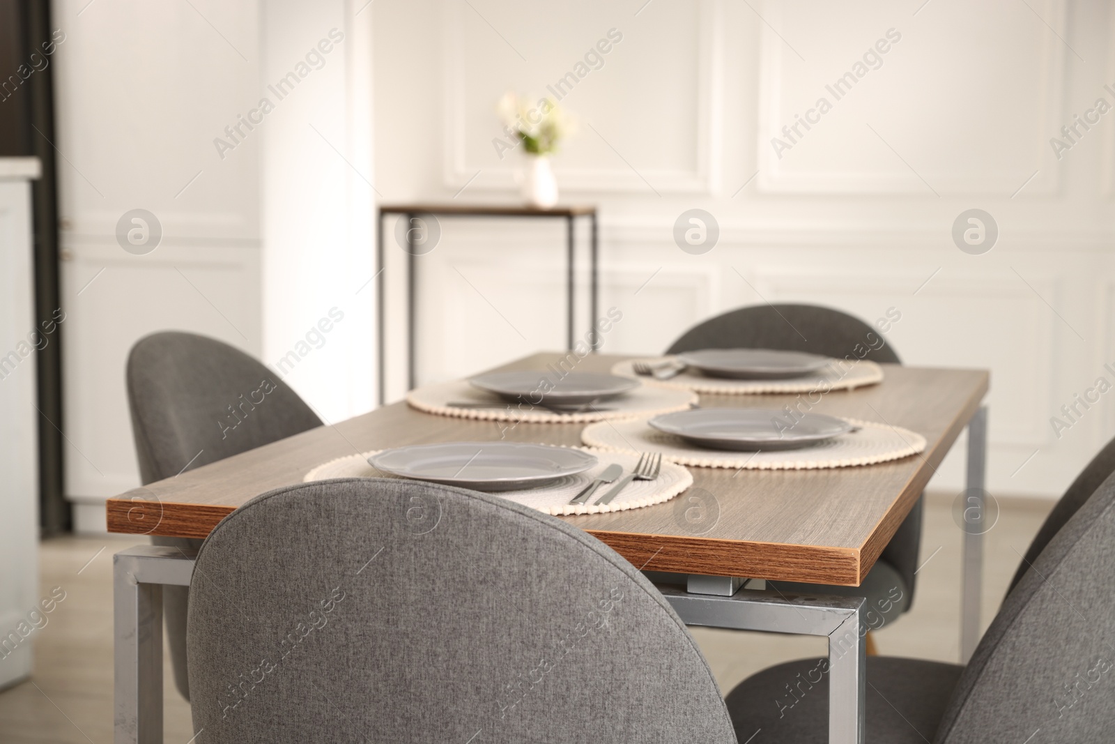 Photo of Stylish table setting and chairs in dining room. Interior design