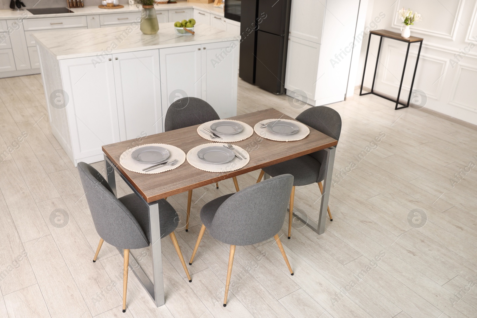 Photo of Kitchen interior with dining table, place setting and grey chairs