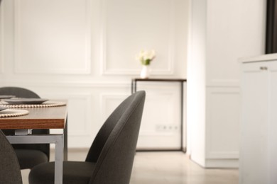 Photo of Stylish table setting and chairs in dining room. Interior design