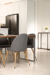 Photo of Kitchen interior with dining table, place setting and grey chairs