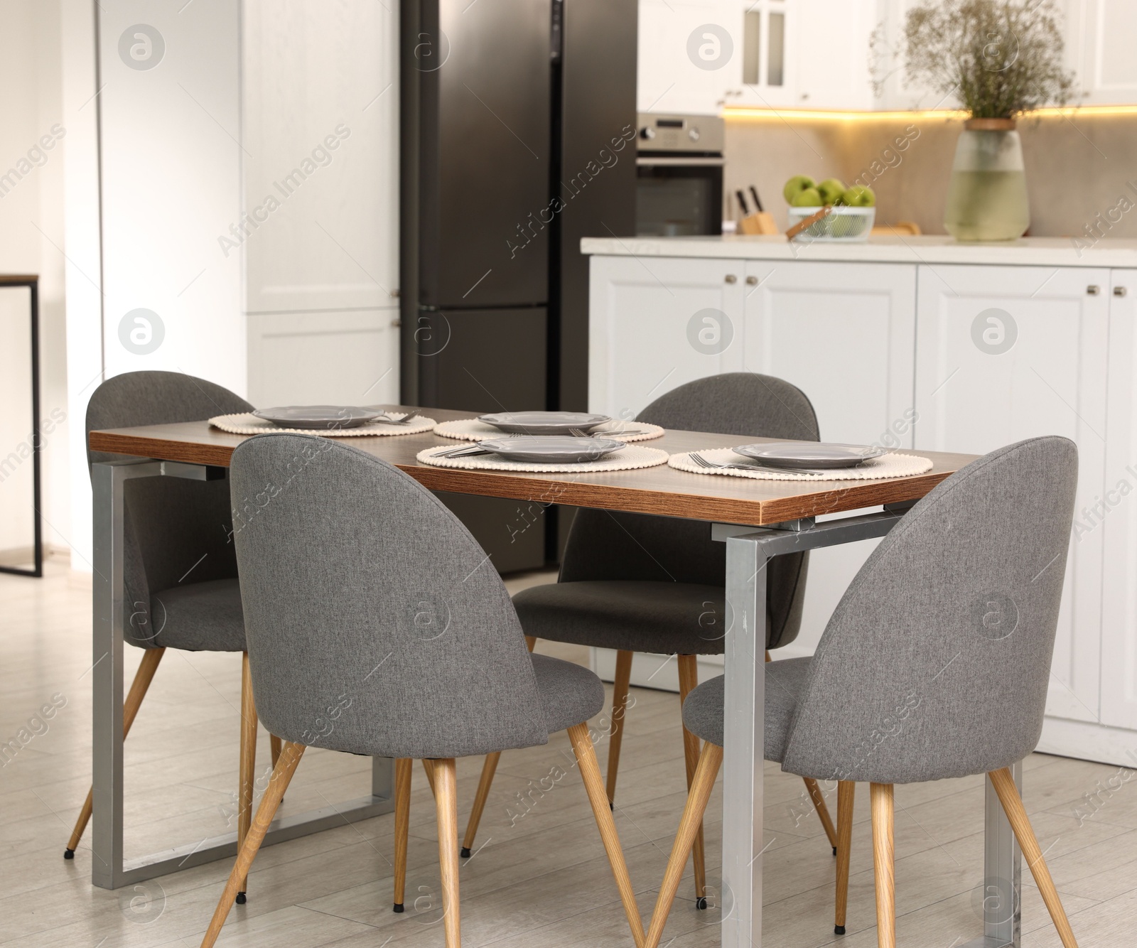 Photo of Kitchen interior with dining table, place setting and grey chairs