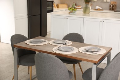Photo of Kitchen interior with dining table, place setting and grey chairs