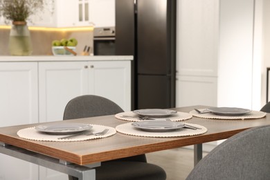 Photo of Kitchen interior with dining table, place setting and grey chairs