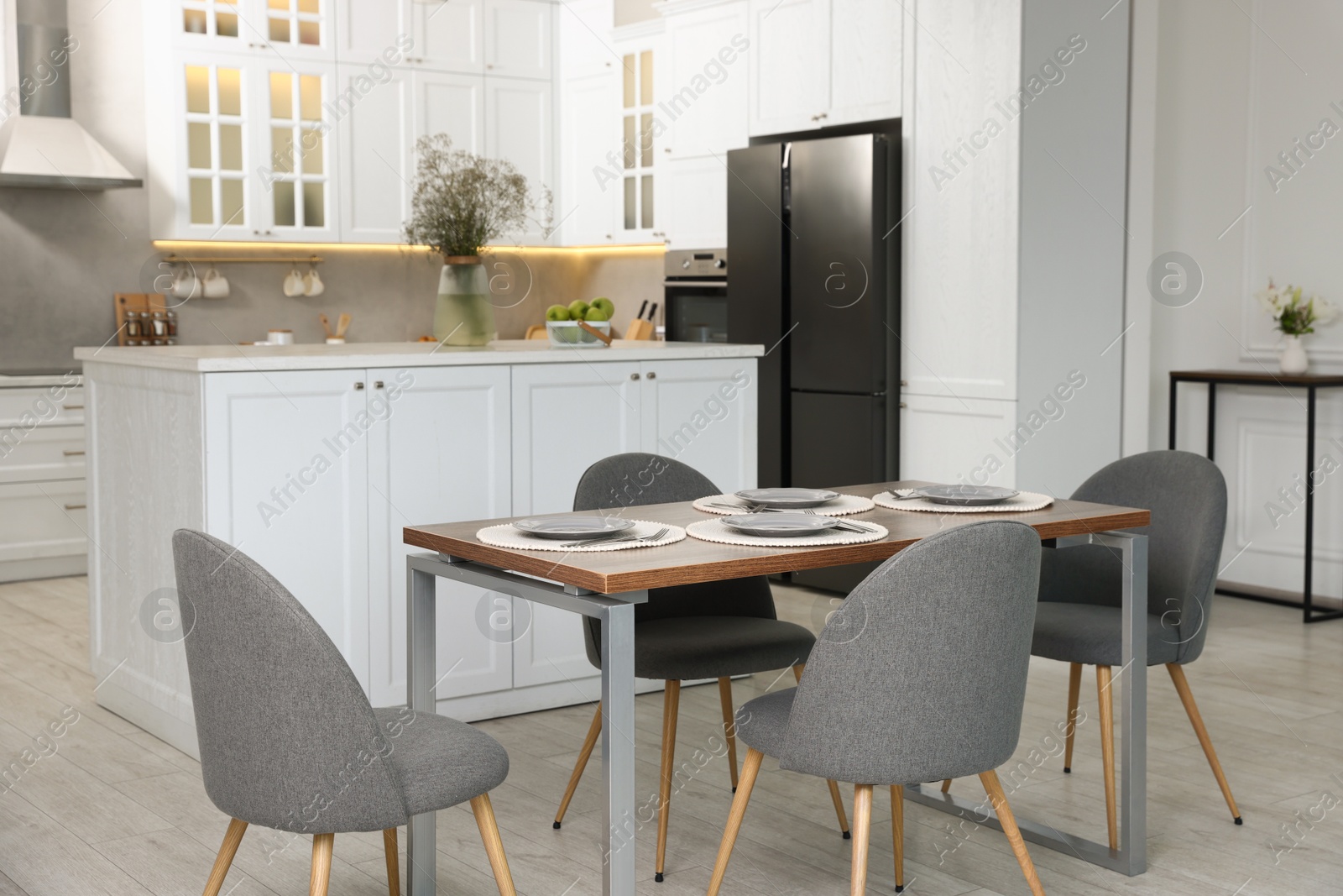 Photo of Kitchen interior with dining table, place setting and grey chairs