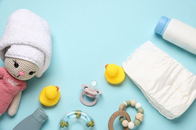 Photo of Baby bath accessories, cosmetic products and toys on light blue background, flat lay
