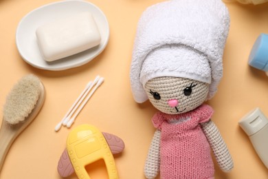 Photo of Baby bath accessories, care products and toys on pale orange background, flat lay