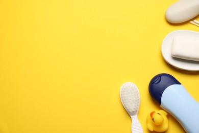 Photo of Baby bath accessories and cosmetic products on yellow background, flat lay. Space for text
