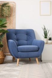 Photo of Comfortable blue armchair in living room. Interior design