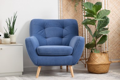 Photo of Comfortable blue armchair in living room. Interior design
