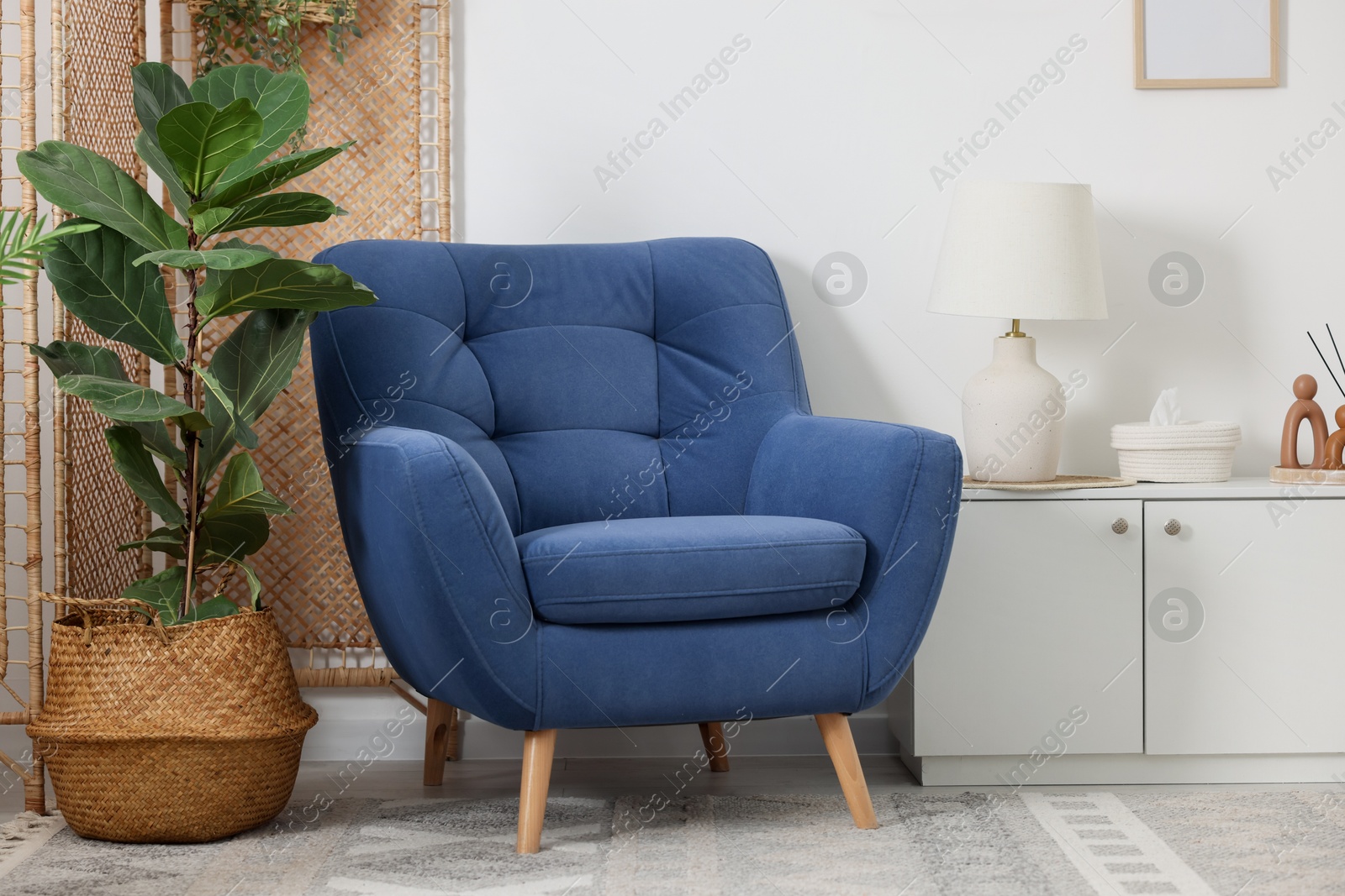Photo of Comfortable blue armchair in living room. Interior design