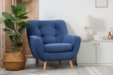 Photo of Comfortable blue armchair in living room. Interior design