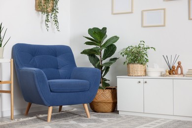 Photo of Comfortable blue armchair in living room. Interior design