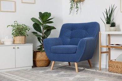 Photo of Comfortable blue armchair in living room. Interior design
