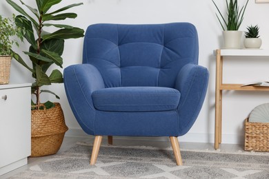 Photo of Comfortable blue armchair in living room. Interior design