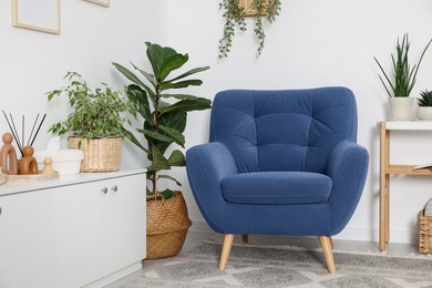 Photo of Comfortable blue armchair in living room. Interior design