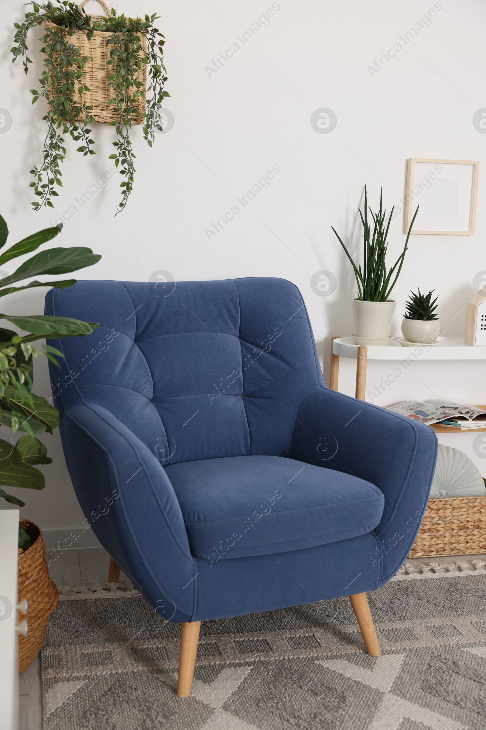 Photo of Comfortable blue armchair in living room. Interior design