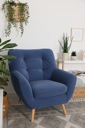 Photo of Comfortable blue armchair in living room. Interior design