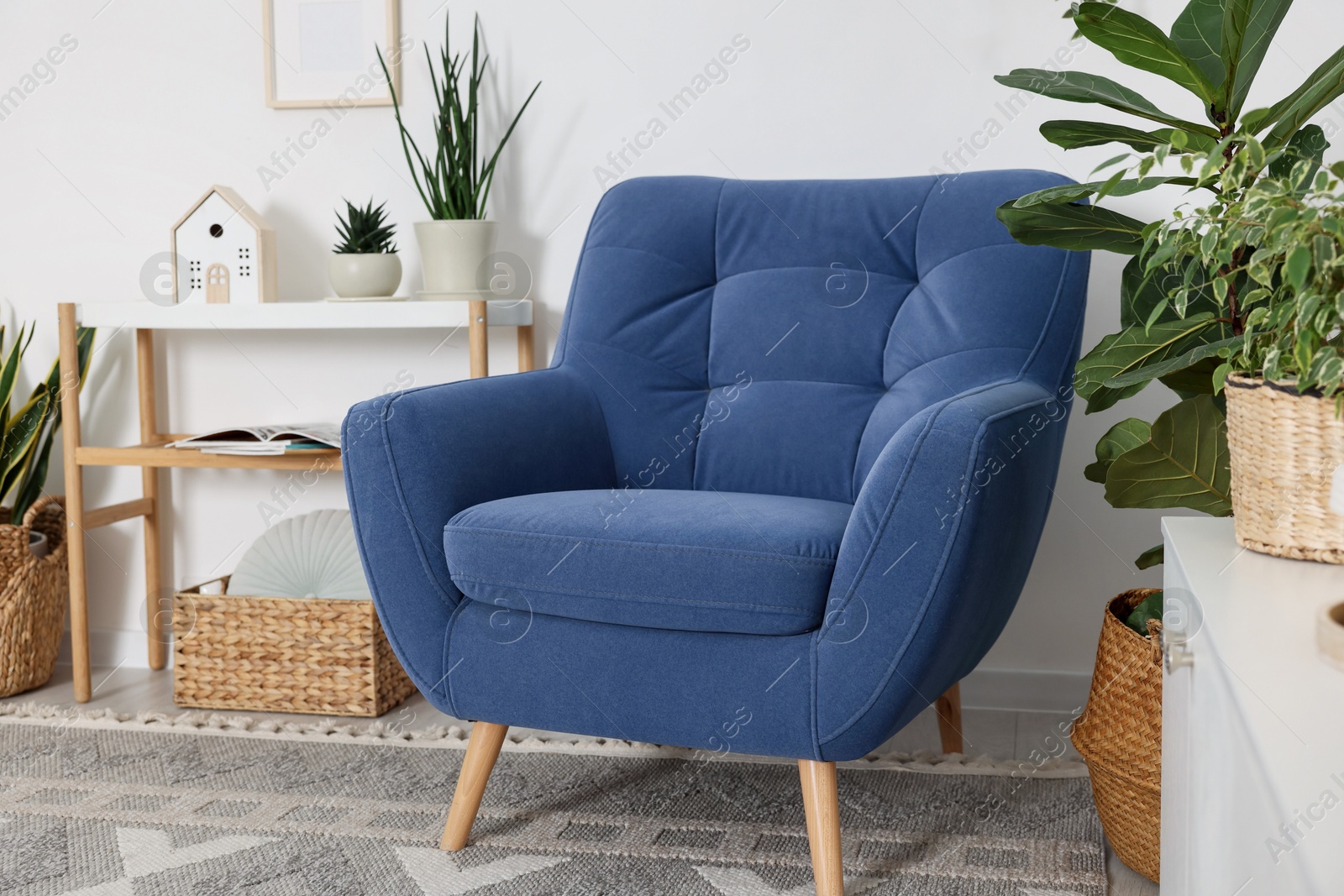 Photo of Comfortable blue armchair in living room. Interior design