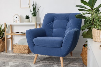 Photo of Comfortable blue armchair in living room. Interior design