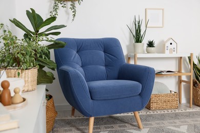 Photo of Comfortable blue armchair in living room. Interior design