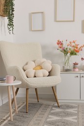 Photo of Stylish armchair with cushion in room. Interior design