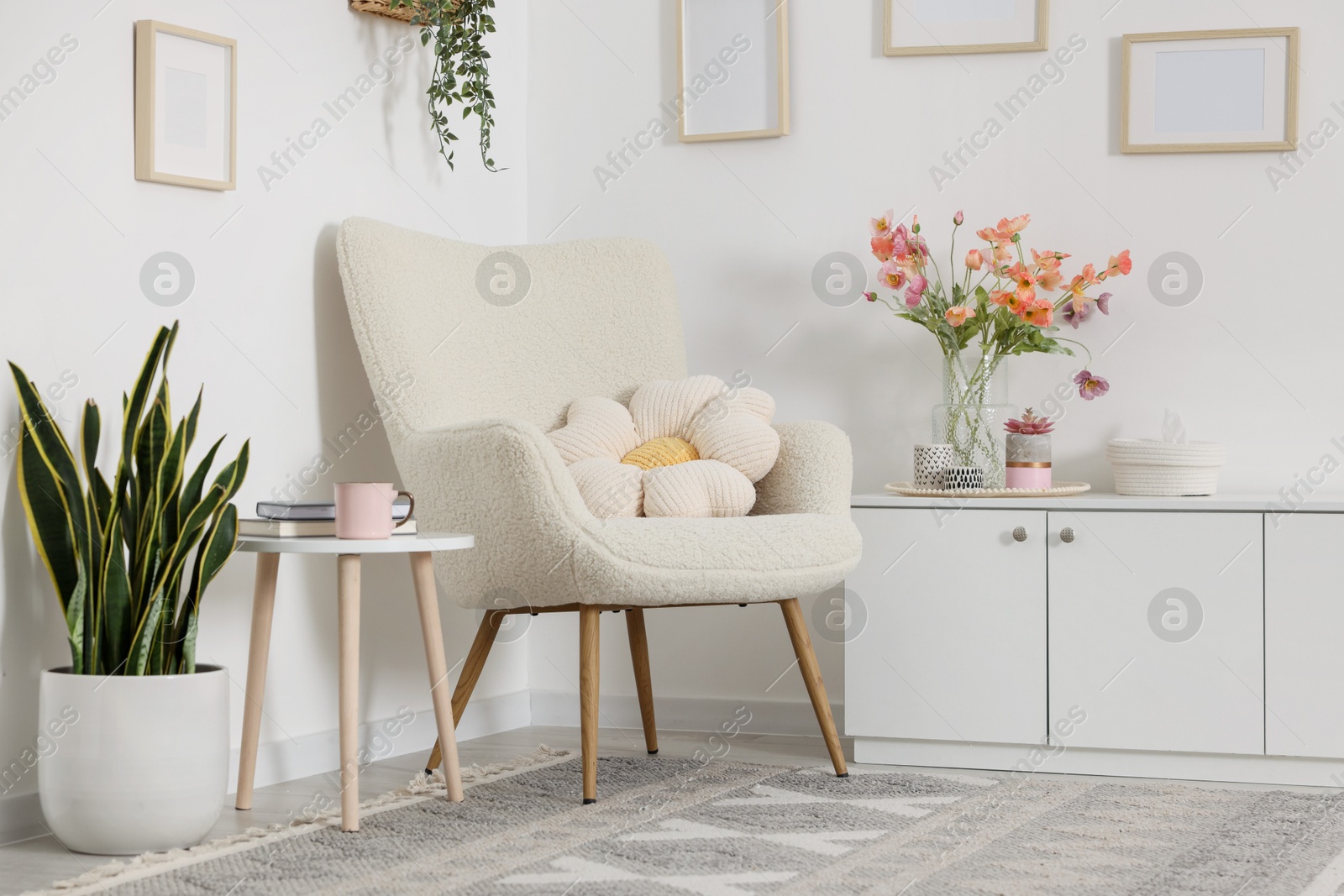 Photo of Stylish armchair with cushion in room. Interior design