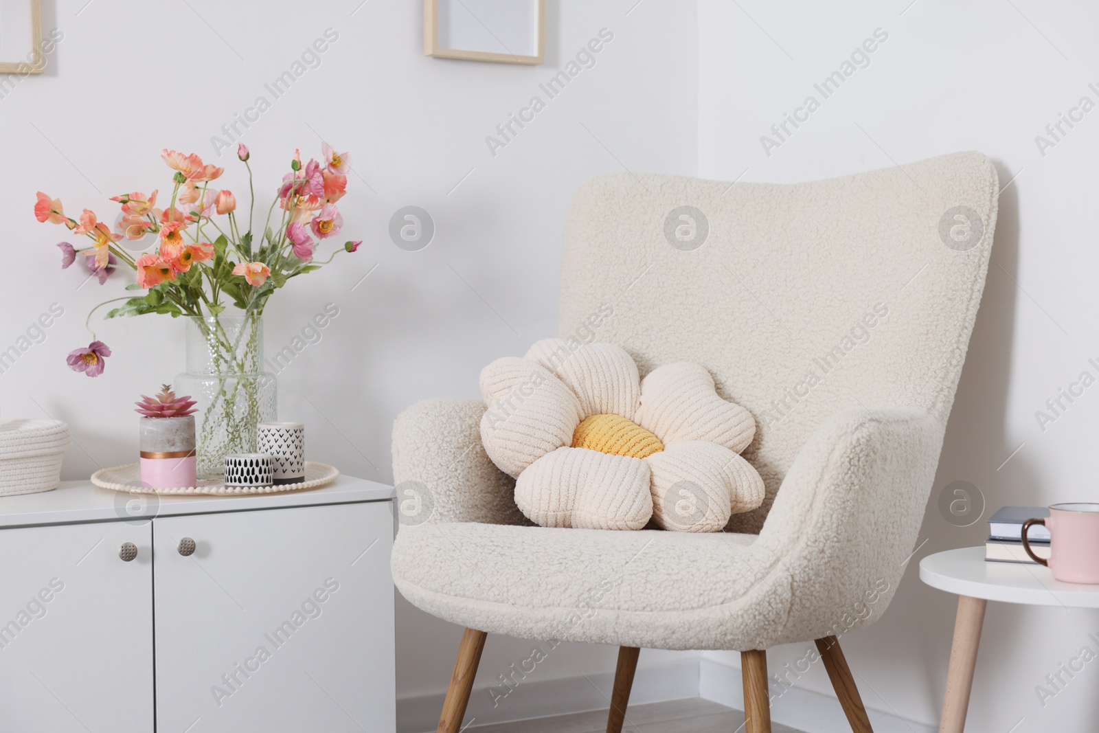 Photo of Stylish armchair with cushion in room. Interior design