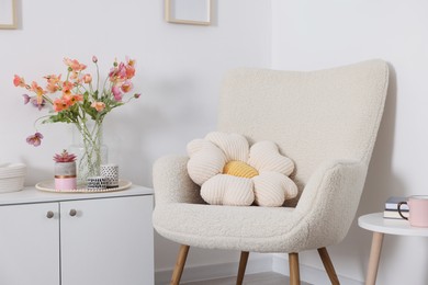 Photo of Stylish armchair with cushion in room. Interior design