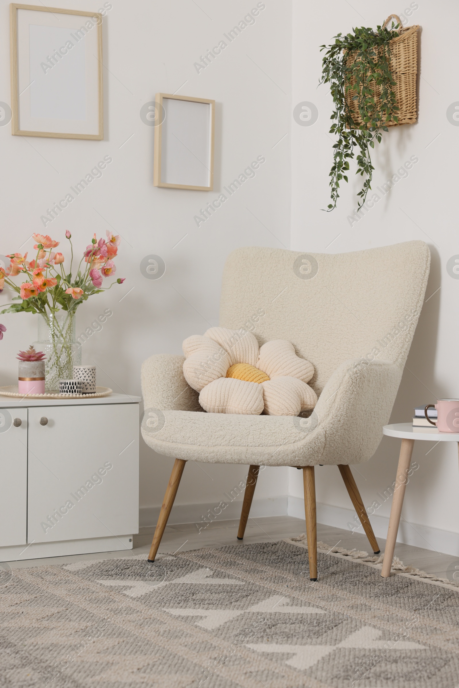 Photo of Stylish armchair with cushion in room. Interior design