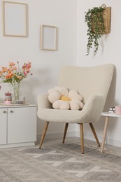Photo of Stylish armchair with cushion in room. Interior design