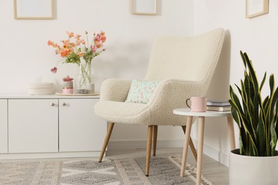 Photo of Stylish armchair with cushion in room. Interior design