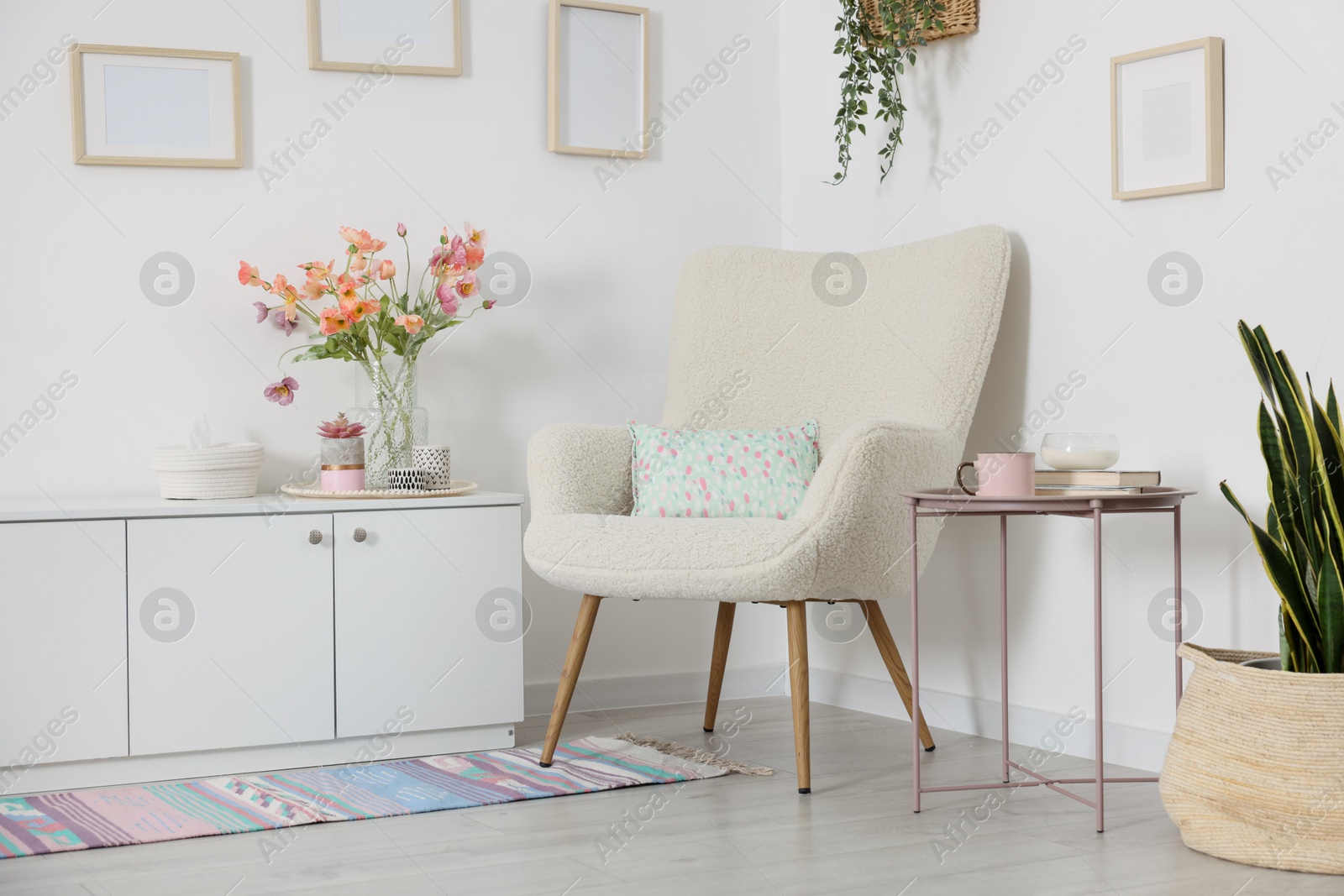 Photo of Stylish armchair with cushion in room. Interior design
