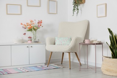 Photo of Stylish armchair with cushion in room. Interior design