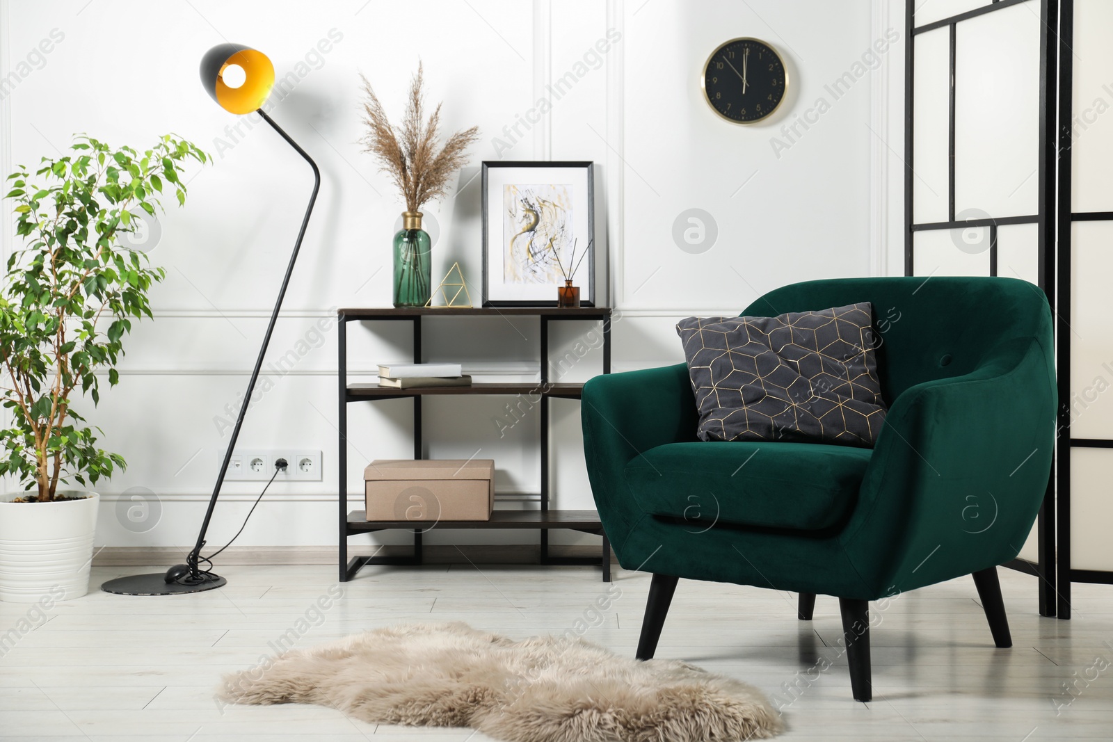 Photo of Stylish armchair with pillow, console table and decor indoors. Interior design