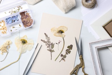 Photo of Flat lay composition with dry flowers and paper on white marble table