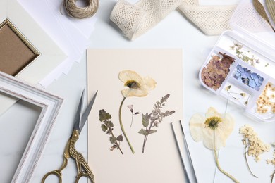 Photo of Flat lay composition with dry flowers and paper on white marble table