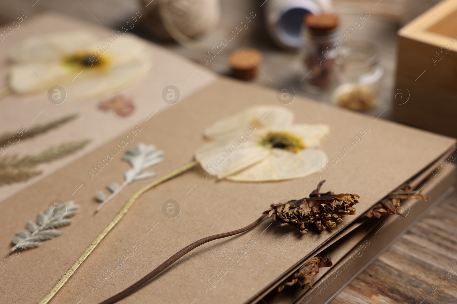 Dry flowers, leaves and notebook on wooden table, closeup Photo of Dry flowers, leaves and notebook on wooden table, closeup