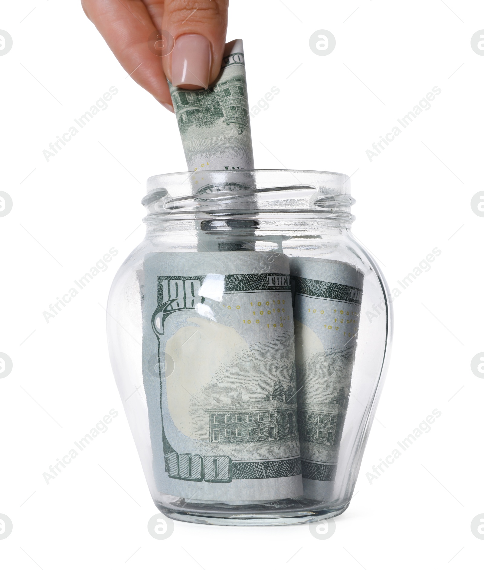 Photo of Woman putting dollar banknote into glass jar on white background, closeup