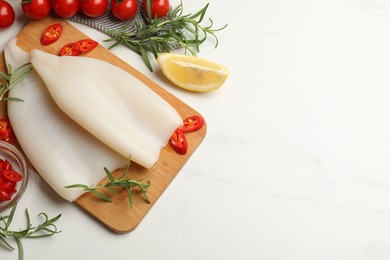 Photo of Pieces of raw squids and products on white table, flat lay. Space for text